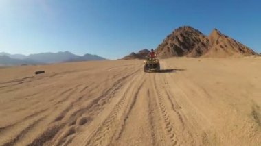 Seksi Kadın Mısır Çölü'nde bir Dört Bisiklet Sürme olduğunu. Hareket halindedinamik görünüm.