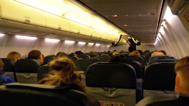 Pasajeros dentro de la cabina de los aviones de pasajeros sentados en las sillas durante el vuelo nocturno — Vídeos de Stock