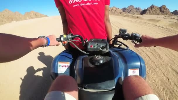 El instructor monta en el maletero de una moto cuádruple. Montar ATV en el desierto de Egipto — Vídeos de Stock