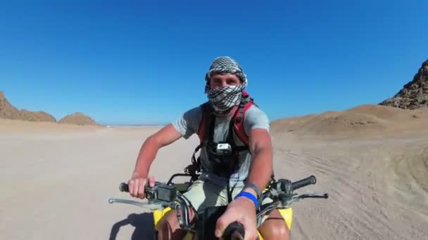 Человек едет на квадроцикле в пустыне Египта и стреляет в себя на экшн-камеру — стоковое видео