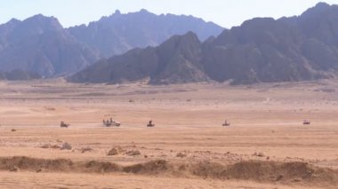 Dağların arka planında Mısır'da Çöl üzerinden Quad Bike Rides Grubu. Sürüş Avs.
