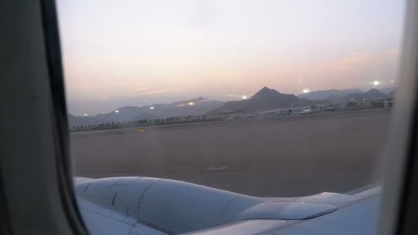 Vista desde la ventana del avión de pasajeros durante el despegue y la aceleración a lo largo de la pista — Vídeo de stock