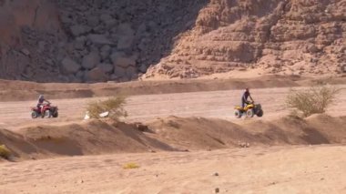 Dağların arka planında Mısır'da Çöl üzerinden Quad Bike Rides Grubu. Sürüş Avs.