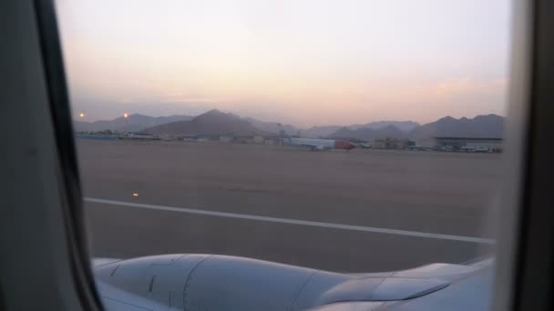 Vista desde la ventana del avión de pasajeros durante el despegue y la aceleración a lo largo de la pista — Vídeo de stock