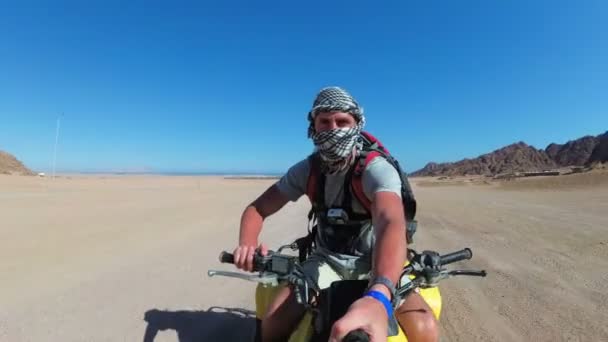 Man is Riding a Quad Bike in Desert of Egypt e atirando em si mesmo em uma câmera de ação — Vídeo de Stock