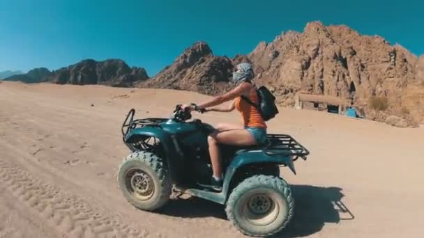 Sexy vrouw rijdt op een quad in de woestijn van Egypte. Dynamische weergave in beweging. — Stockvideo