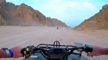 Mısır Çölü 'nde bir avluya binmek. Birinci şahıs görüşü. ATV bisikleti sürüyor.