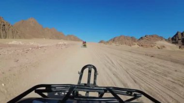 Mısır Çölü 'nde bir avluya binmek. Birinci şahıs görüşü. ATV bisikleti sürüyor.