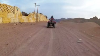 Kadın Mısır Çölü'nde Bir Quad Bike Biniyor. Hareket halindedinamik görünüm.