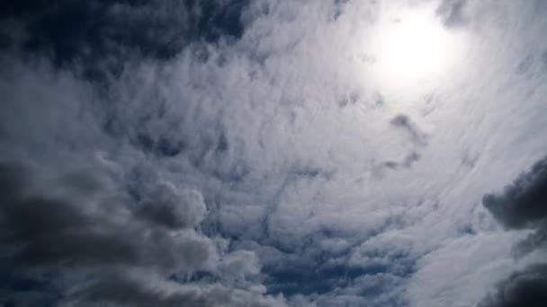 Las nubes se mueven suavemente en el cielo azul sobre el fondo del sol. Cronograma — Vídeos de Stock