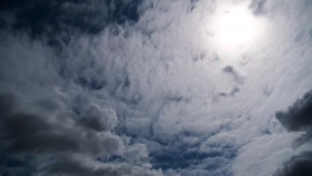 Nuages se déplacent en douceur dans le ciel bleu sur fond de soleil. Temps écoulé 