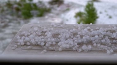 Pencerenin Dışında Selam. Dolu parçaları plastik bir pencerenin arkasındaki pencere üzerinde yatıyor.