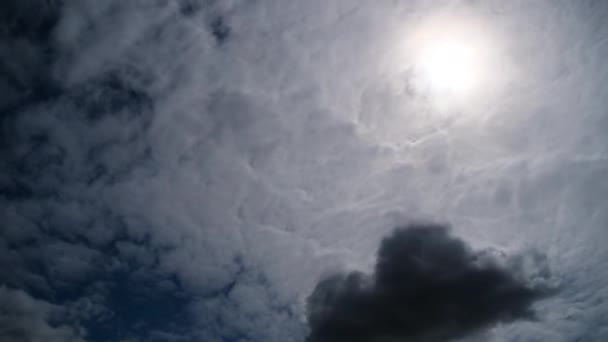 Wolken bewegen soepel in de blauwe hemel op de achtergrond van de zon. timelapse — Stockvideo