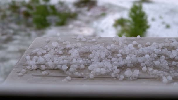 Salve fuera de la ventana. Pedazos de granizo yacen en el alféizar de la ventana detrás de una ventana de plástico . — Vídeos de Stock