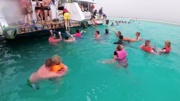 Grupa turystów pływa w Morzu Czerwonym w pobliżu łodzi rekreacyjnych. Nurkowanie na otwartym morzu. — Wideo stockowe
