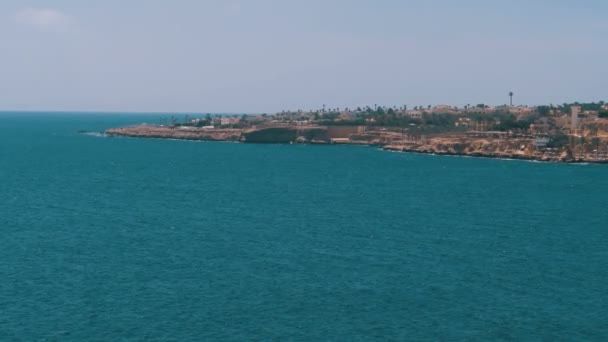 Praia em uma baía na costa com ondas no mar azul e recifes de coral . — Vídeo de Stock