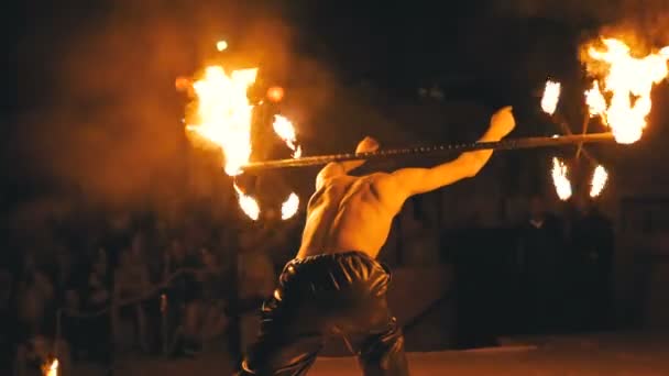 Παράσταση πυρκαγιάς στην σκηνή. Νέος άντρας που χορεύει με φλογερό φαν σε μια νυχτερινή εκπομπή. Αργή κίνηση — Αρχείο Βίντεο