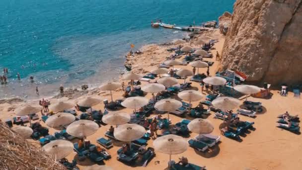 Egypt, pláž s deštníky a lehátky na Rudém moři nedaleko korálového útesu. — Stock video