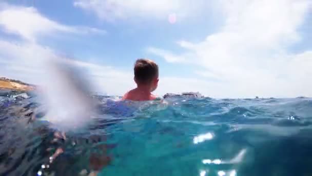 Blick unter Wasser auf ein Kind in Schwimmflossen, das im Roten Meer in einem Resort in Ägypten schwimmt — Stockvideo