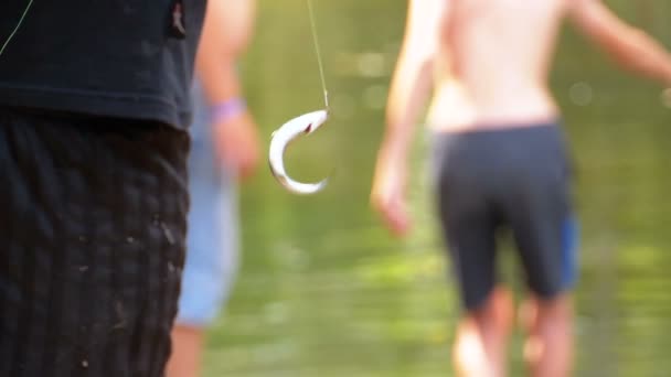 Peixe pego oscila em um gancho suspenso em uma linha de pesca. A pescar. Movimento lento — Vídeo de Stock