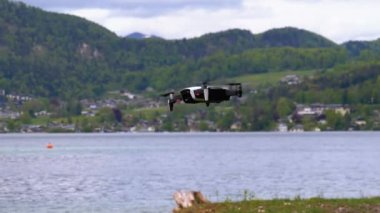 Göl ve Dağların Arkasında Havada Asılı Dönen Pervaneli Drone