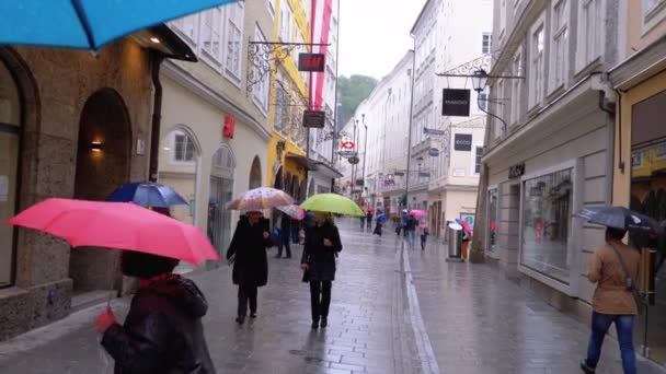 Ludzie z parasolami spacer na ulicach starego Salzburga podczas deszczu. Austria — Wideo stockowe