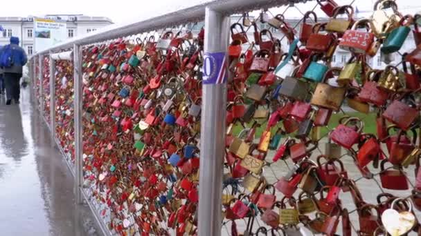 Muchas cerraduras de colores colgando de pasamanos en el puente del amor en Salzburgo, Austria — Vídeos de Stock