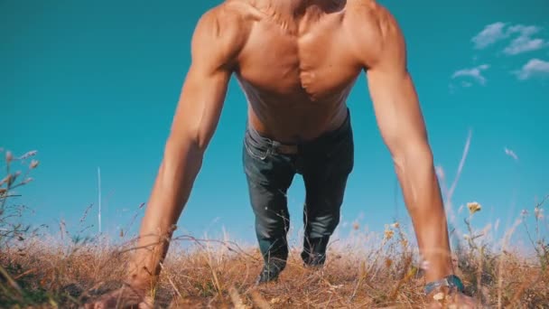 Entraînement. Homme fort faisant des pompes avec des applaudissements à l'extérieur sur la nature. Mouvement lent — Video