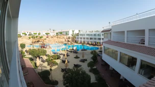Курортний готель з блакитним плавальним басейном, парасольками та шезлонгами в Єгипті — стокове відео