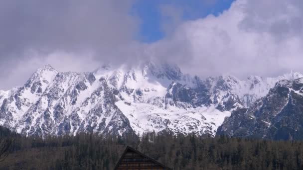 Cima delle montagne innevate tra le nuvole. Strbske Pleso. Slovacchia. Alti Tatra — Video Stock