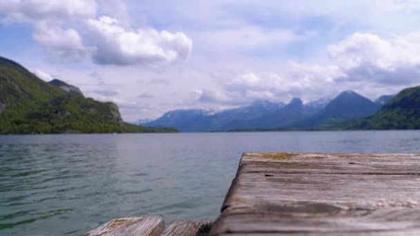 Muelle de madera en el fondo de un lago de montaña y Alpes nevados. Austria. Lago Wolfgangsee — Vídeo de stock