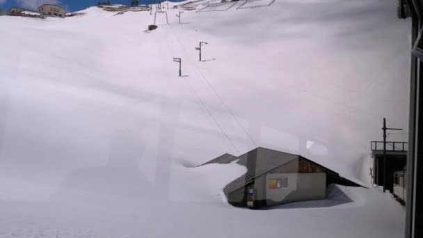 Wąskotorowa jazda pociągiem turystycznym w ośnieżonych górach. Szwajcaria, Alpy — Wideo stockowe
