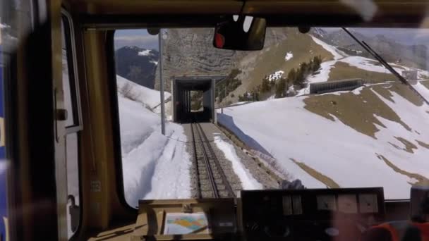 Fensterblick auf eine fahrende Bergbahn auf den verschneiten Schweizer Alpen. Stadt Montreux. — Stockvideo