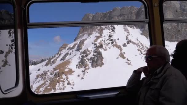 Vue fenêtre d'un train de montagne en mouvement sur les Alpes suisses enneigées. Montreux City . — Video