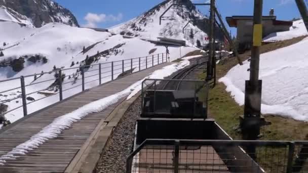 Kugghjulståget Rider i de snöiga bergen på järnvägen. Schweiz, Alperna — Stockvideo