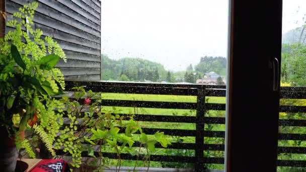 Lluvia fuera de la ventana. Gotas de lluvia en el cristal de una ventana de plástico . — Vídeo de stock