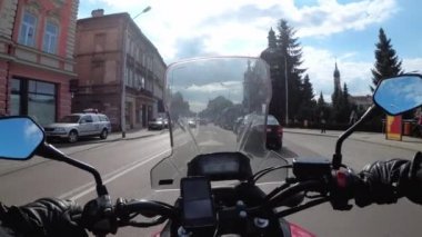 Moto bisikletçi şehirde bir motosiklet sürmek. Bir motosikletin direksiyonundan görüntüle.