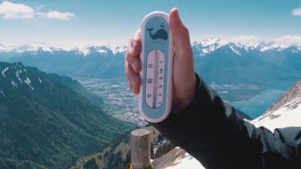 Hand houdt een thermometer op de top van de Alpen in Zwitserland. Rochers-de-Naye. — Stockvideo
