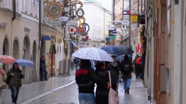 Ludzie z parasolami spacer na ulicach starego Salzburga podczas deszczu. Austria — Wideo stockowe