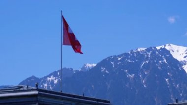 Evin Çatısında Duran Alp Dağları'nın Arka Planında İsviçre Bayrağı