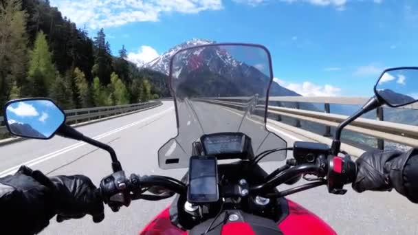 Motorrijder rijdt op prachtige landschap bergweg in de buurt van besneeuwde Zwitserland Alpen — Stockvideo