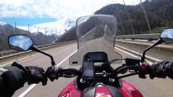 Motorradfahrer fährt auf wunderschöner Gebirgsstraße in der Nähe der verschneiten Schweizer Alpen — Stockvideo