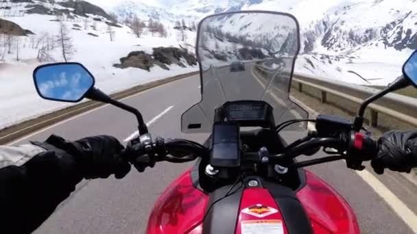 Motociclista Passeios em uma bela paisagem Snowy Mountain Road perto de Alpes suíços. Suíça . — Vídeo de Stock