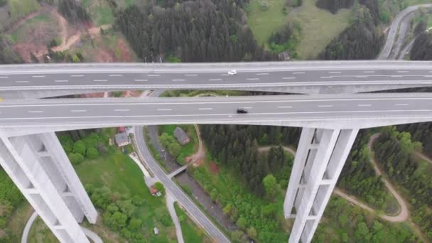 Luchtfoto van het viaduct van de snelweg op betonnen pilaren in de bergen — Stockvideo