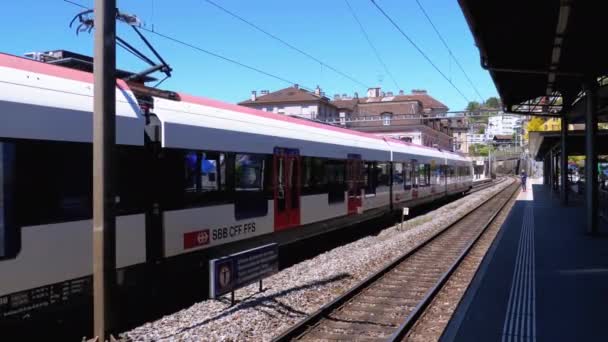 スイス駅近代的な列車は、鉄道駅のプラットホームに到着します. — ストック動画