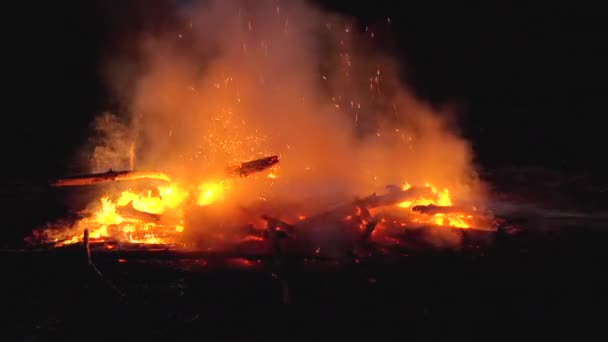 Гасіння великого вогню з водою пожежним шлангом вночі у повільному русі — стокове відео