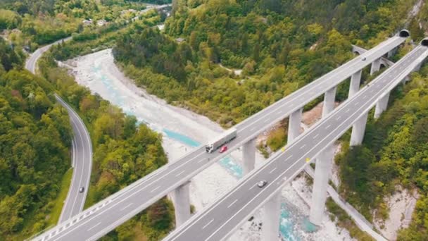 Letecký pohled na betonovou dálnici viadukt na betonových pilířích v horách — Stock video