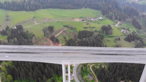 Vista aérea del viaducto de la autopista sobre pilares de hormigón con tráfico en las montañas — Vídeos de Stock