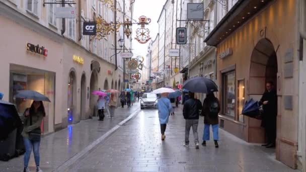 Personas con paraguas caminan por las calles de la antigua Salzburgo durante la lluvia. Austria — Vídeos de Stock