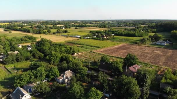 4k Luftaufnahme der Landschaft und des kleinen Dorfes mit grünen Feldern und Wiesen — Stockvideo